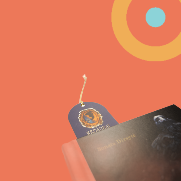 Skirtukas knygoje. Išsikišusi viršutinė skirtuko dalis, matosi senasis Kėdainių miesto herbas ir aukso spalvos juostelė.